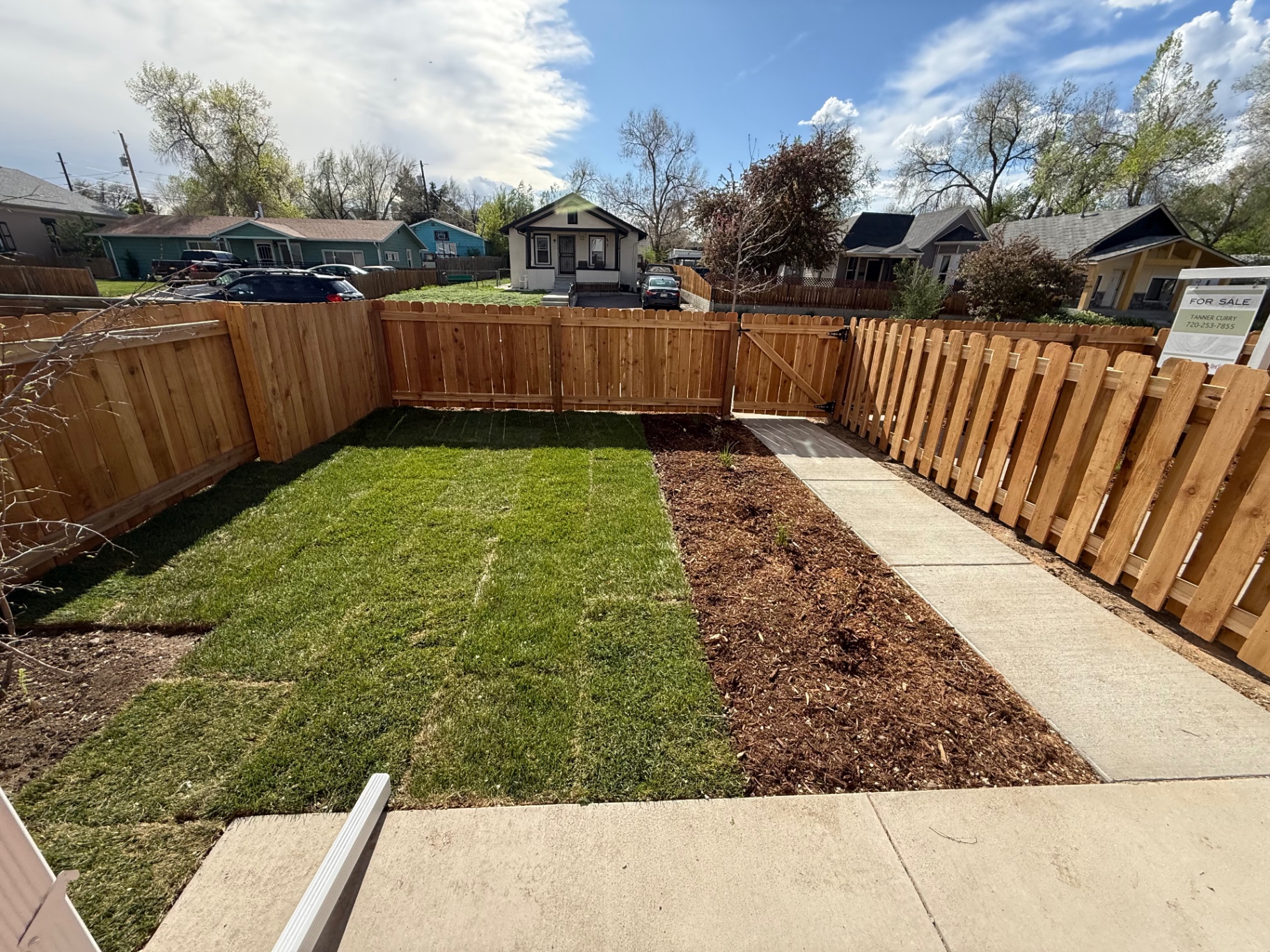 New cedar privacy fence and matching walk gate around a landscaped backyard