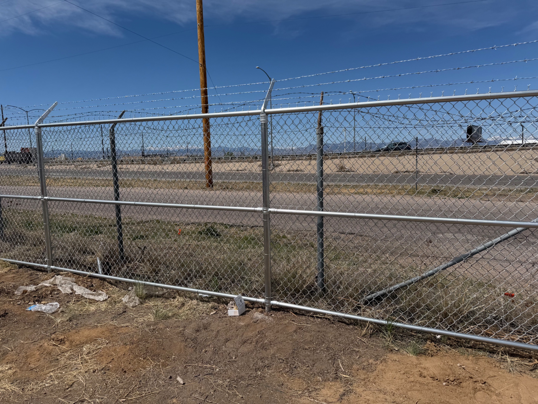Galvanized chain link fence and brace panel securing an industrial perimeter